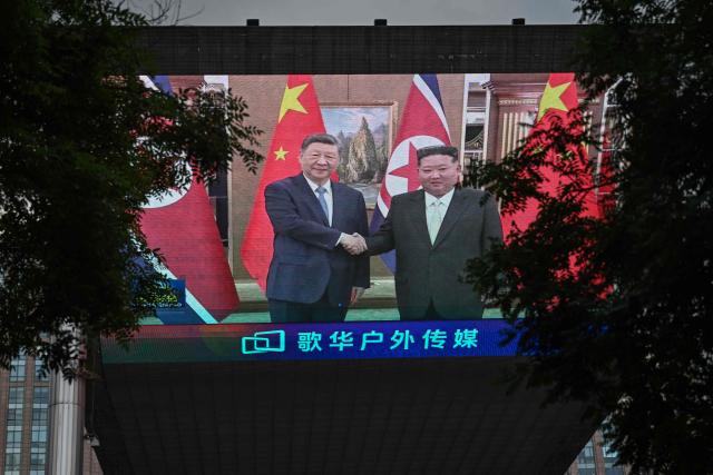 TOPSHOT - This picture shows a giant screen displayed outside a shopping mall in Beijing on June 8, 2026, showing a news program about the meeting between China's President Xi Jinping and North Korean leader Kim Jong Un held in North Korea. China's President Xi Jinping made a rare visit to North Korea on June 8, where he proclaimed a willingness to bring ties to "new heights" during a meeting with Kim Jong Un. (Photo by Pedro PARDO / AFP)