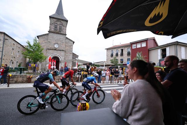 Groupama-FDJ United's French rider Clément Braz Afonso (R), Lotto Intermarche's French rider Baptiste Veistroffer (C) and Bahrain Victorious's Belgian rider Vlad Van Mechelen (L) cycle in a breakaway past the Saint Bonnet church in Saint-Bonnet-le-Froid during the 2nd stage of the Tour Auvergne-Rhone-Alpes cycling race (formerly known as the Criterium du Dauphine), 234,3km between Saint-Martin-Le-Vinoux in the French Alps and Le Puy-en-Velay near the Massif Central, on June 8, 2026. (Photo by Anne-Christine POUJOULAT / AFP)