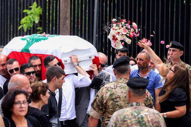A mourner throws flowers at the coffin of Lebanese army captain Elie Khoury, who was killed by Israeli bombardment, during his funeral in his home village of Kfar Jarra near Jezzine in southern Lebanon on June 8, 2026. An Israeli strike in southern Lebanon killed three soldiers, Beirut's military said on June 6, as its chief travelled to Pakistan to meet with a key mediator in efforts to end the Middle East war. Israel has launched an operation in Lebanon to root out the Tehran-backed armed group Hezbollah, which drew Lebanon into the wider Middle East war by launching missiles on behalf of its sponsor. (Photo by MAHMOUD ZAYYAT / AFP)