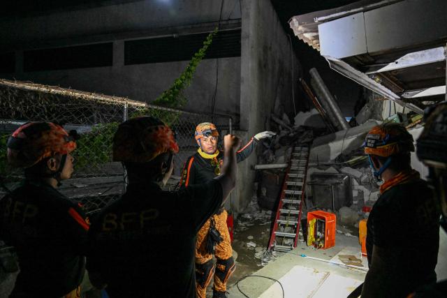 Responders assess a collapsed building after a 7.8 magnitude earthquake in General Santos City on June 8, 2026. The earthquake in the southern Philippines killed at least 31 people, according to provincial authorities, after toppling buildings and sparking tsunami warnings across the region. (Photo by Jam STA ROSA / AFP)