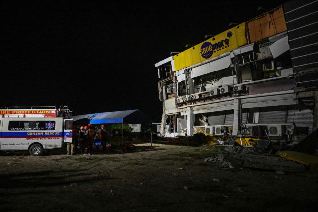 Responders gather as they assess a collapsed building after a 7.8 magnitude earthquake in General Santos City on June 8, 2026. The earthquake in the southern Philippines killed at least 31 people, according to provincial authorities, after toppling buildings and sparking tsunami warnings across the region. (Photo by Jam STA ROSA / AFP)