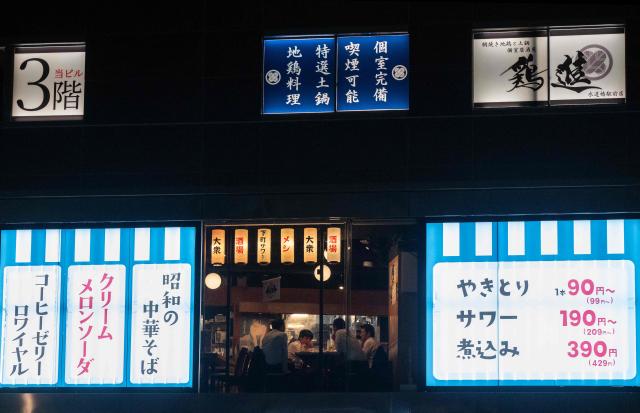 A group of men drink in a bar in a building in Tokyo on June 8, 2026. (Photo by Andrew CABALLERO-REYNOLDS / AFP)