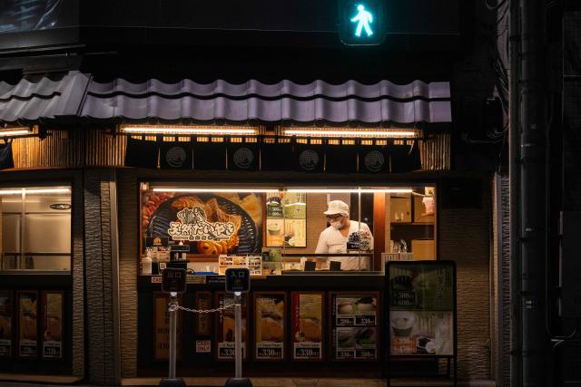 A chef cooks inside of a restaurant on a street corner in Tokyo on June 8, 2026. (Photo by Andrew CABALLERO-REYNOLDS / AFP)