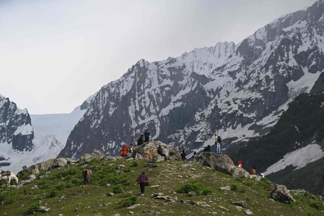 Tourists enjoy the view of the scenic Thajwas glacier, a popular sightseeing destination in Sonamarg on June 8, 2026. (Photo by TAUSEEF MUSTAFA / AFP)