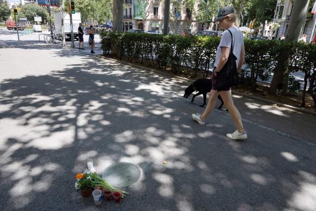 A woman looks at a commemorative plaque in Barcelona on June 8, 2026, placed at the site where Sagrada Familia architect Antoni Gaudi was struck by a tram on June 7, 1926, leading to his death three days later in a hospital. Pope Leo XIV visits Spain from June 6-12, with stops in Madrid, Barcelona and the Canary Islands. In Barcelona, the pontiff is expected to visit the Sagrada Familia, where he will inaugurate its tallest tower, the Tower of Jesus Christ, during a ceremony marking the 100th centenary of the death of Gaudi, who designed the landmark. (Photo by Josep LAGO / AFP)