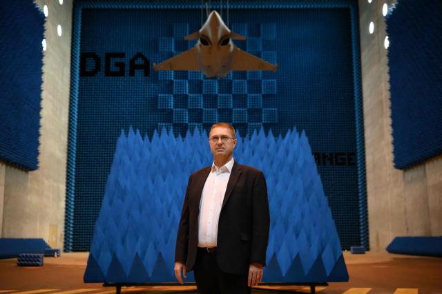 French Director of the Center for Expertise and Testing of the DGA MI Frederic Bouyer poses under a Rafale F4 fighter aircraft hanging in the SOLANGE (Systeme Orientable Lourd pour Aeronefs et Gros Engins) room of the DGA (Direction Generale de l'Armement) Maitrise de l'Information (MI) in Bruz, western France, on June 8, 2026. The Solange facility is dedicated to evaluating the radar signature of full-scale aircraft, such as the Rafale, or large missiles. These measures make it possible to evaluate aircraft in the face of the various radar threats they may encounter in an operational configuration. (Photo by Loic VENANCE / AFP)