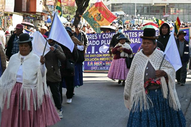 People with white flags take part in a march against the blockades in La Paz on June 8, 2026. Bolivia's legislature gave the green light on June 7, 2026 for President Rodrigo Paz to use the military to clear roadblocks that have crippled key cities for weeks. (Photo by AIZAR RALDES / AFP)