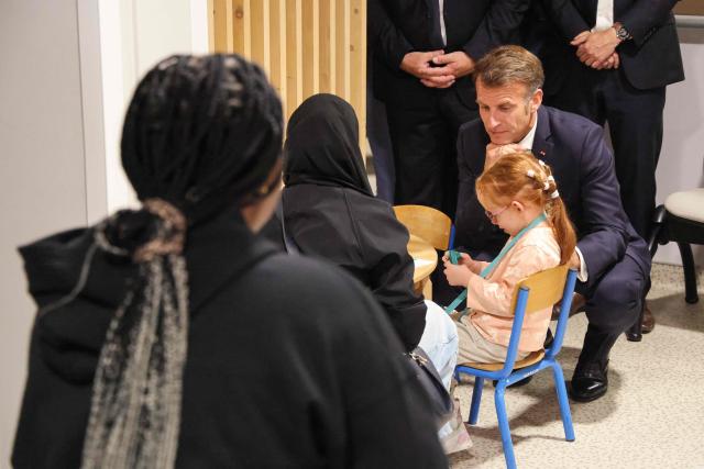 France's President Emmanuel Macron (C) meets with parents and children during a visit of the Institute for Neurodevelopmental Disorders at the Amiens-Picardie University Hospital (CHU) in Amiens, northern France, on June 8, 2026. (Photo by Ludovic MARIN / POOL / AFP)