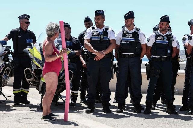 A beach goer speaks to police officers gathering along the promenade in Catalans beach during the prefecture’s press conference to announce of security measures implemented on Marseille’s beaches, in southeastern France, on June 8, 2026. (Photo by Thibaud MORITZ / AFP)