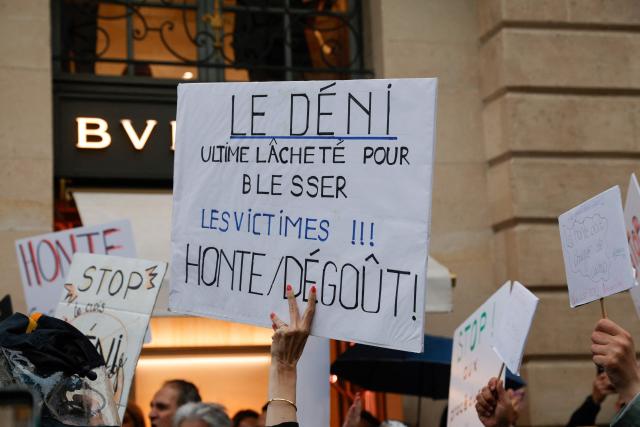 A person holds a placard reading "Denial, the ultimate cowardice to
hurt he victims !!! Shame/ Disgust!" as people gather at Place Vendome outside the French Justice Ministry in Paris on June 8, 2026, at the call of the Mouv'Enfants collective and other organisations, to demand a law against violence on minors, following the death of Lyhanna, an 11-year-old girl found dead on June 4 after being reported missing on May 29 in southwestern France, on June 8, 2026. (Photo by GEOFFROY VAN DER HASSELT / AFP)