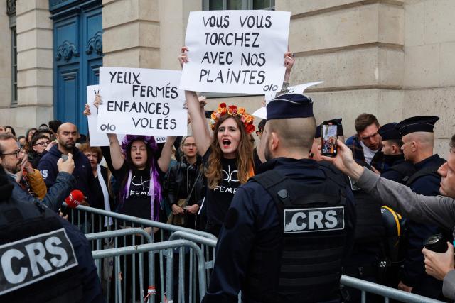 Members of international radical feminist activist group FEMEN take part in an unauthorised demonstration near Place Vendome outside the French Justice Ministry in Paris on June 8, 2026, at the call of the Mouv'Enfants collective and other organisations, to demand a law against violence on minors, following the death of Lyhanna, an 11-year-old girl found dead on June 4 after being reported missing on May 29 in southwestern France, on June 8, 2026. The placard reads : "Eyes closed (looking away), Stolen childhood" (L) and "You wipe your ass with our complaints". (Photo by GEOFFROY VAN DER HASSELT / AFP)