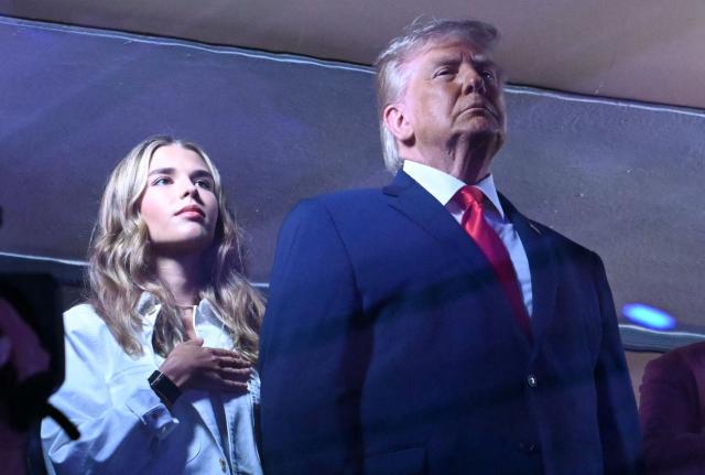 Kai Trump and her grandfather US President Donald Trump stand during the National Anthem as they attend Game Three of the NBA Finals between the San Antonio Spurs and the New York Knicks at Madison Square Garden in New York on June 8, 2026. (Photo by SAUL LOEB / AFP)