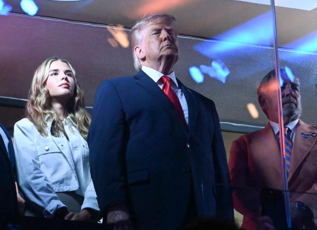 Kai Trump (L), US President Donald Trump (C) and Knicks owner James Dolan stand during the National Anthem as they attend Game Three of the NBA Finals between the San Antonio Spurs and the New York Knicks at Madison Square Garden in New York on June 8, 2026. (Photo by SAUL LOEB / AFP)