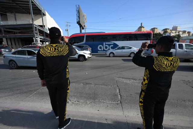 Members of Mexico's National Guard record with their mobile phones the arrival of the bus transporting Iran's national football team at the Caliente Stadium for a training session in Tijuana, Mexico, on June 8, 2026, ahead of the FIFA 2026 World Cup football tournament. (Photo by Guillermo Arias / AFP)