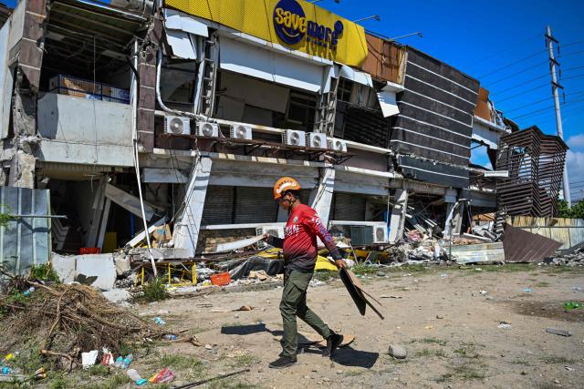 A responder prepares to take part in search and rescue operations outside a collapsed building after a 7.8 magnitude earthquake in General Santos City on June 9, 2026. A 7.8-magnitude earthquake in the southern Philippines on June 8 killed at least 35 people, according to provincial authorities, after toppling buildings and sparking tsunami warnings across the region. (Photo by Jam STA ROSA / AFP)