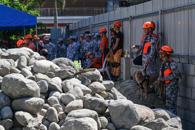 Responders standby as they prepare for search and rescue operations outside a collapsed building after a 7.8 magnitude earthquake in General Santos City on June 9, 2026. A 7.8-magnitude earthquake in the southern Philippines on June 8 killed at least 35 people, according to provincial authorities, after toppling buildings and sparking tsunami warnings across the region. (Photo by Jam STA ROSA / AFP)