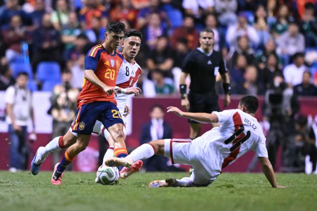 Spain's midfielder #20 Pedri conrols the ball while Peru's midfielder #11 Jairo Velez defends during the international friendly football match between Peru and Spain at Cuauhtemoc Stadium in Puebla, Mexico, on June 8, 2026. (Photo by CARL DE SOUZA / AFP)