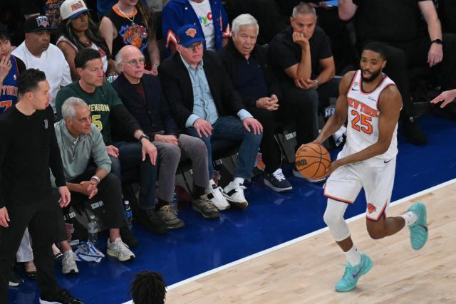 Knicks guard-forward Mikal Bridges handles the ball while former White House chief of staff Rahm Emanuel (3L), actor Larry David (3R) and Patriots owner Robert Kraft (R) watch Game Three of the NBA Finals between the San Antonio Spurs and the New York Knicks at Madison Square Garden in New York, on June 8, 2026. (Photo by SAUL LOEB / AFP)
