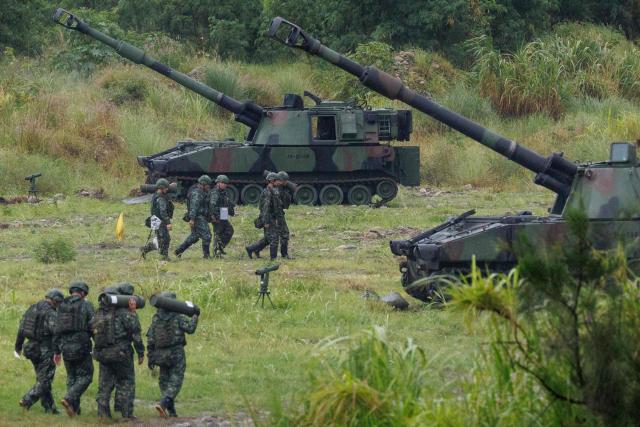 Taiwanese soldiers carry artillery shells for an M109A2 self-propelled howitzer during a live-fire training exercise in Taichung on June 9, 2026. (Photo by CHENG Yu-chen / AFP)