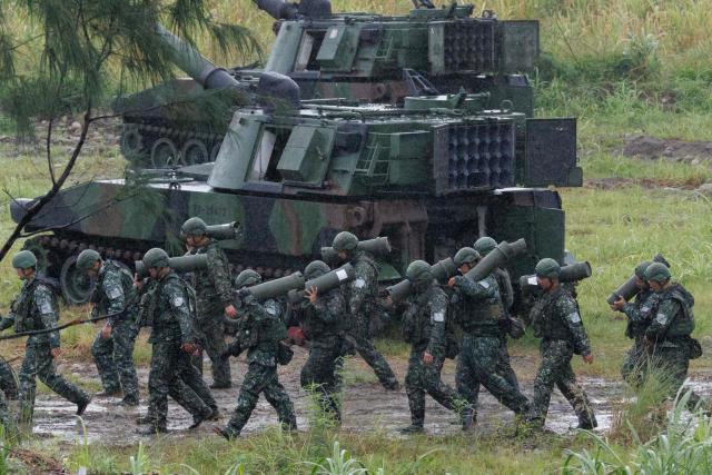 Taiwanese soldiers carry artillery shells for an M109A2 self-propelled howitzer during a live-fire training exercise in Taichung on June 9, 2026. (Photo by CHENG Yu-chen / AFP)