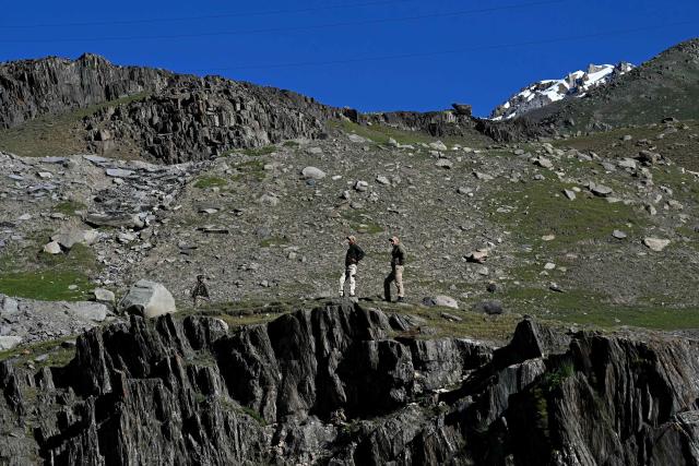 Police personnel stand guard near the Zojila tunnel, India's longest road tunnel project connecting Jammu and Kashmir state with the Ladakh region on June 9, 2026. (Photo by TAUSEEF MUSTAFA / AFP)