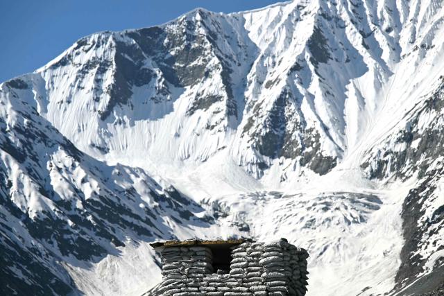 A security forces bunker is seen in the backdrop of snow-covered mountains near the Zojila tunnel, India's longest road tunnel project connecting Jammu and Kashmir state with the Ladakh region on June 9, 2026. (Photo by TAUSEEF MUSTAFA / AFP)