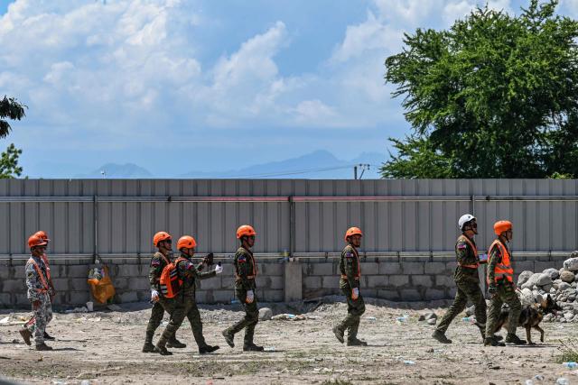 Responders and a rescue dog conduct search and rescue operations at the site of a collapsed building after a 7.8 magnitude earthquake in General Santos City on June 9, 2026. A 7.8-magnitude earthquake in the southern Philippines on June 8 killed at least 35 people, according to provincial authorities, after toppling buildings and sparking tsunami warnings across the region. (Photo by Jam STA ROSA / AFP)