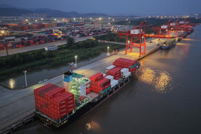 Containers and ships are seen at the port in Nanjing, in China’s eastern Jingsu province early on June 9, 2026. China's exports to the United States surged 35.4 percent year-on-year last month, official data showed on June 9, 2026, weeks after President Donald Trump visited Beijing with trade high on the agenda. (Photo by CN-STR / AFP) / China OUT