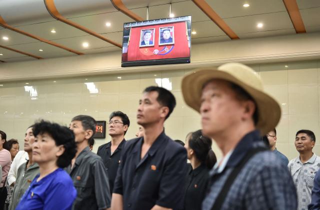 People watch a news program on the visit of China's President Xi Jinping, in the Kaeson Station of the Pyongyang Metro in Pyongyang on June 9, 2026. China's President Xi Jinping made a rare visit to North Korea on June 8, where he proclaimed a willingness to bring ties to "new heights" during a meeting with Kim Jong Un. (Photo by KIM Won Jin / AFP)