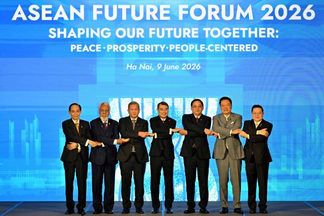 (L-R) Vietnam's Minister of Foreign Affairs Le Hoai Trung, East Timor's Prime Minister Xanana Gusmao, Cambodia's Prime Minister Hun Manet, Vietnam's Prime Minister Le Minh Hung, Laos' Prime Minister Sonexay Siphandone, Thailand's Prime Minister Anutin Charnvirakul and Association of Southeast Asian Nations (ASEAN) Secretary General Kao Kim Hourn chain their hands as they pose for a group photo at the ASEAN Future Forum 2026 at the Melia Hotel in Hanoi on June 9, 2026. (Photo by Nhac NGUYEN / AFP)
