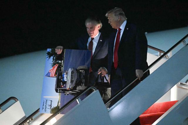 US Secretary of the Interior Doug Burgum and US President Donald Trump disembark from Air Force One upon arrival at Joint Base Andrews in Maryland, on June 9, 2026. Trump is returning to the White House after attending Game Three of the NBA Finals. (Photo by SAUL LOEB / AFP)