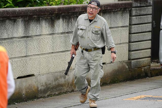 A Japanese zoo staff member carries a tranquilizer gun to sedate a bear as hunters and officials search for the wild animal in Utsunomiya, north of Tokyo, on June 9, 2026. A bear roaming the streets of a Japanese city for days forced the closure of nearly 100 schools, as dozens of hunters and officials searched for the animal. (Photo by Yuichi YAMAZAKI / AFP)
