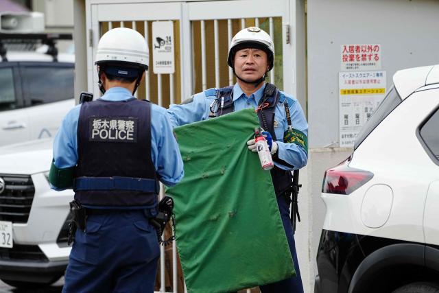 Japanese police prepare equipment as hunters and officials search for a wild bear in Utsunomiya, north of Tokyo, on June 9, 2026. A bear roaming the streets of a Japanese city for days forced the closure of nearly 100 schools, as dozens of hunters and officials searched for the animal. (Photo by Yuichi YAMAZAKI / AFP)