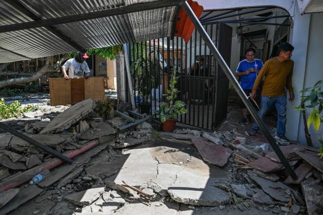 People clean up their damaged house after a 7.8 magnitude earthquake in General Santos City on June 9, 2026. A 7.8-magnitude earthquake in the southern Philippines on June 8 killed at least 35 people, according to provincial authorities, after toppling buildings and sparking tsunami warnings across the region. (Photo by Jam STA ROSA / AFP)