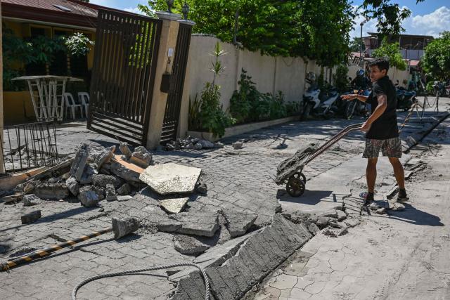 A man cleans up the debris from a damaged house after a 7.8 magnitude earthquake in General Santos City on June 9, 2026. A 7.8-magnitude earthquake in the southern Philippines on June 8 killed at least 35 people, according to provincial authorities, after toppling buildings and sparking tsunami warnings across the region. (Photo by Jam STA ROSA / AFP)