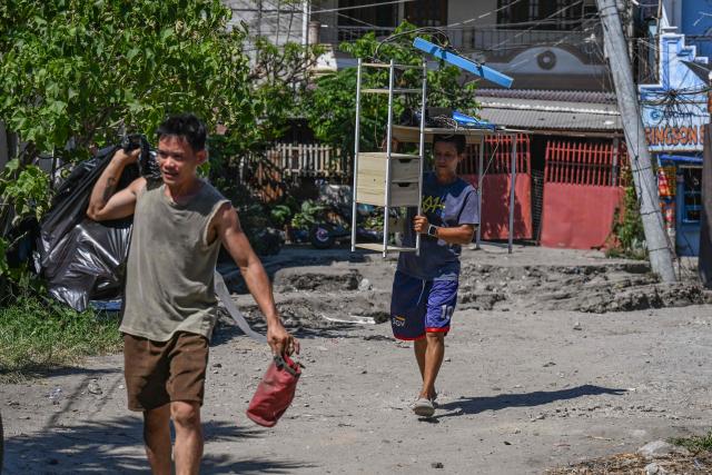 Residents gather their belongings after a 7.8 magnitude earthquake in General Santos City on June 9, 2026. A 7.8-magnitude earthquake in the southern Philippines on June 8 killed at least 35 people, according to provincial authorities, after toppling buildings and sparking tsunami warnings across the region. (Photo by Jam STA ROSA / AFP)