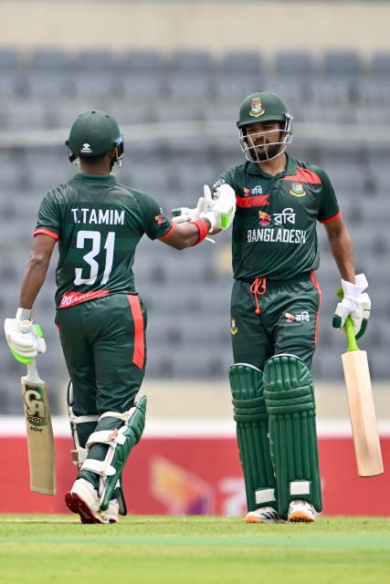 Bangladesh's players Najmul Hossain Shanto (R) and Tanzid Hasan (L) celebrate after scoring half-century (50 runs) during the first one-day international (ODI) cricket match between Bangladesh and Australia at the Sher-e-Bangla National Cricket Stadium in Dhaka on June 9, 2026. (Photo by MUNIR UZ ZAMAN / AFP)