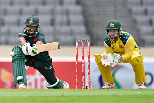 Bangladesh's Najmul Hossain Shanto plays a shot as Australia’s captain and wicketkeeper Josh Inglis looks on during the first one-day international (ODI) cricket match between Bangladesh and Australia at the Sher-e-Bangla National Cricket Stadium in Dhaka on June 9, 2026. (Photo by MUNIR UZ ZAMAN / AFP)