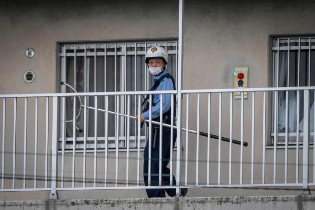 A police officer holding animal capture equipment looks for a wild bear during a widescale search for the animal in Utsunomiya, north of Tokyo, on June 9, 2026. A bear roaming the streets of a Japanese city for days forced the closure of nearly 100 schools, as dozens of hunters and officials searched for the animal. (Photo by Yuichi YAMAZAKI / AFP)