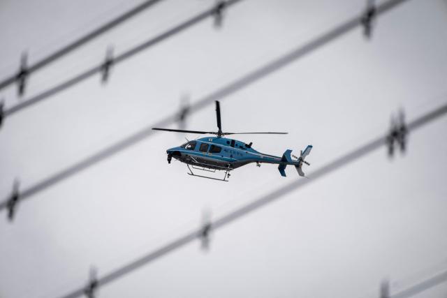 A police helicopter flies over a residential area during a search for a wild bear in Utsunomiya, north of Tokyo, on June 9, 2026. A bear roaming the streets of a Japanese city for days forced the closure of nearly 100 schools, as dozens of hunters and officials searched for the animal. (Photo by Yuichi YAMAZAKI / AFP)
