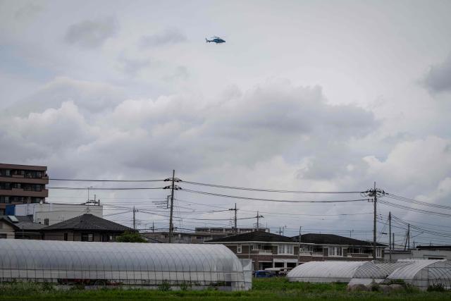 A police helicopter flies over a residential area during a search for a wild bear in Utsunomiya, north of Tokyo, on June 9, 2026. A bear roaming the streets of a Japanese city for days forced the closure of nearly 100 schools, as dozens of hunters and officials searched for the animal. (Photo by Yuichi YAMAZAKI / AFP)