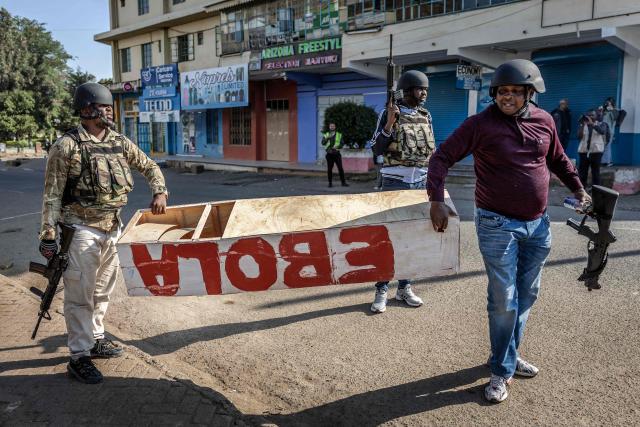 Kenyan police officers hold a mock coffin abandoned in a street by protesters during a demonstration against a controversial US-built Ebola quarantine centre slated to begin operations at Laikipia Air Base in Nanyuki on June 9, 2026. Several Kenyans were arrested on June 9, 2026 in the latest protests against an Ebola quarantine centre being built for US citizens in a tourist town.
The centre at Laikipia Air Base in the town of Nanyuki, under the shadow of Mount Kenya, is set to quarantine Americans arriving from the Democratic Republic of Congo (DRC), which is battling a major Ebola outbreak. (Photo by Luis TATO / AFP)