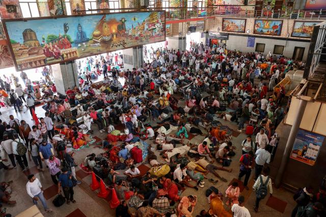 Passengers rest under fans inside a railway station on a hot summer day in Varanasi on June 9, 2026. (Photo by Niharika KULKARNI / AFP)