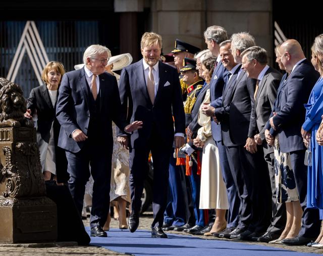 German President Frank-Walter Steinmeier (C-L) waves to Netherlands' former Prime Minister Jan-Peter Balkenende (4R) as he walks with Netherlands' King Willem-Alexander (C) upon arrival at Dam Square in Amsterdam on June 9, 2026. German President Frank-Walter Steinmeier is paying a three-day state visit to the Netherlands. (Photo by Remko de Waal / ANP / AFP) / Netherlands OUT