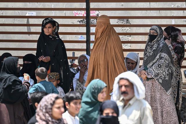Commuters stand under a bus shelter as they wait to board an air-conditioned bus on a hot summer day in Rawalpindi on June 9, 2026.  (Photo by Aamir QURESHI / AFP)