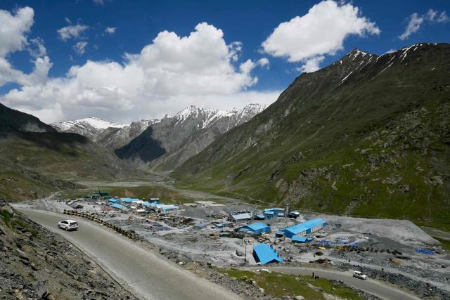 A vehicle rides past a construction site near the Zojila tunnel, India's longest road tunnel project connecting Jammu and Kashmir with the Ladakh region, in Minamarg on June 9, 2026. Indian engineers broke through the final rock section in the strategic Zojila tunnel through a Himalayan mountain on June 9, a milestone in providing all-weather access to the frontier Ladakh region with China. (Photo by Tauseef MUSTAFA / AFP)