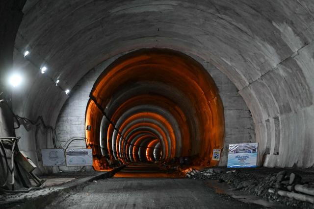 Lights illuminate the Zojila tunnel, India's longest road tunnel project connecting Jammu and Kashmir with the Ladakh region, in Minamarg on June 9, 2026. Indian engineers broke through the final rock section in the strategic Zojila tunnel through a Himalayan mountain on June 9, a milestone in providing all-weather access to the frontier Ladakh region with China. (Photo by Tauseef MUSTAFA / AFP)