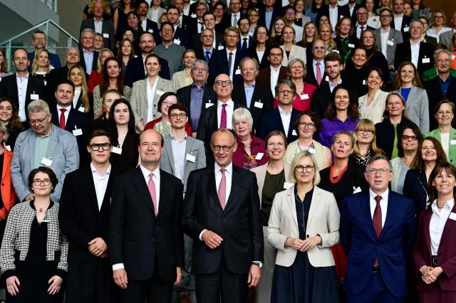 German Chancellor Friedrich Merz (front C) and German State Minister for Sport and Voluntary Work Christiane Schenderlein (front 3rdR) pose with laureates for a group photo during the awarding ceremony of the "startsocial 2026" prize for voluntary commitment at the Chancellery in Berlin on June 9, 2026. In all, 25 outstanding initiatives will be honored for their exemplary voluntary commitment, seven initiatives are awarded cash prizes totaling 35,000 euros. The Chancellor is patron of the 'startsocial' competition. (Photo by John MACDOUGALL / AFP)
