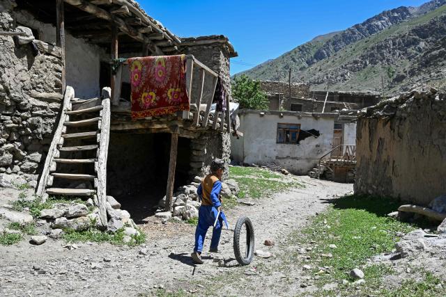 An Afghan boy plays with a tyre in Eshtiwi village in the Parun district of Afghanistan's Nuristan province on June 8, 2026. (Photo by Wakil KOHSAR / AFP)
