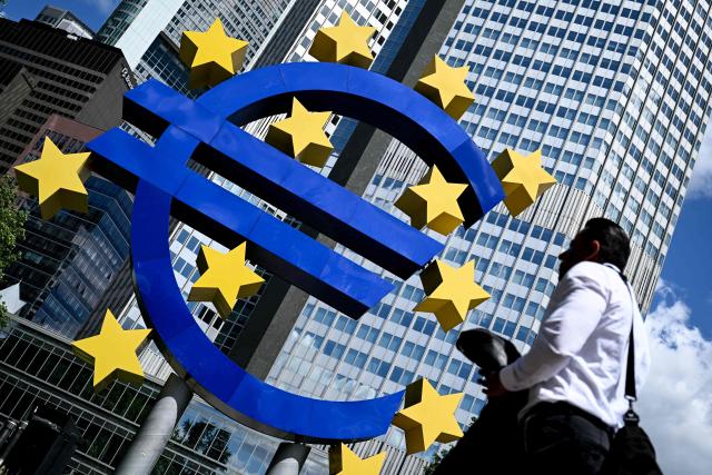 A man walks past the Euro currency sign ('Euro Sculpture' by German artist Ottmar Hoerl) in front of the former European Central Bank (ECB) building in Frankfurt am Main, western Germany, on June 9, 2026. The ECB holds its next meeting on Thursday, June 11. (Photo by Kirill KUDRYAVTSEV / AFP)